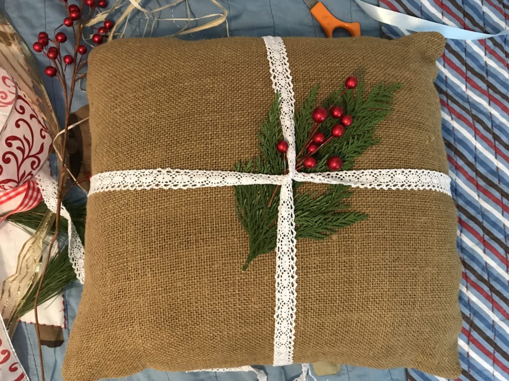 Adding the berries to the burlap pillow. Part of Step 2 in upgrading a burlap pillow to a Christmas front porch rocking chair pillow for Christmas.